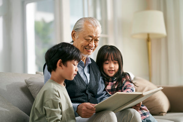 Older man reading to two young children